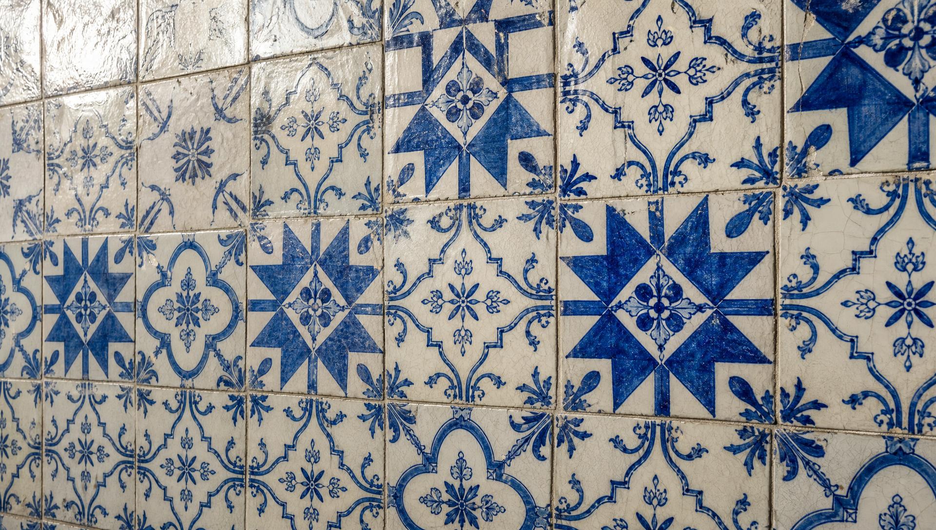 Hand-painted blue-and-white Portuguese azulejo tiles covering a sunlit wall